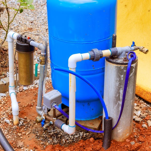 PVC water pipe is being connected to a water supply artesian well system pump house